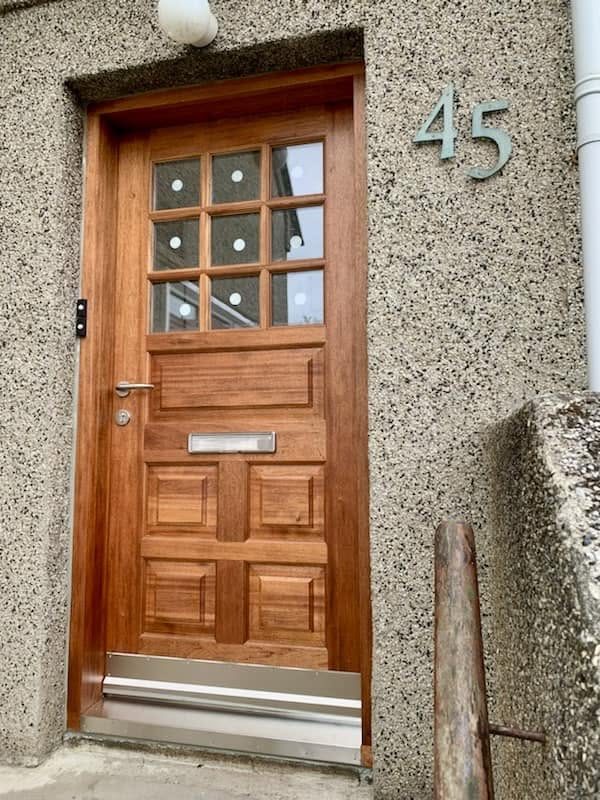 Útihurð úr viði með níu rúðum og fulningum, við húsnúmerið 45.