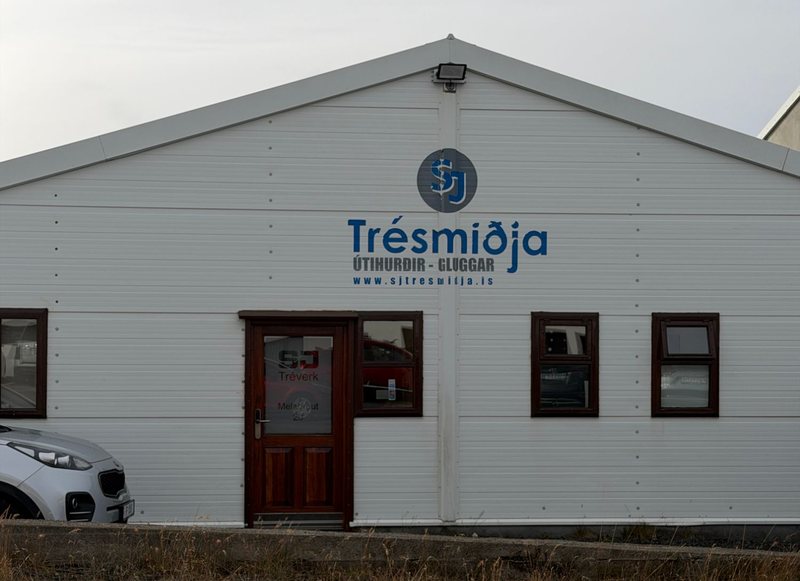 Verkstæði SJ Tréverks á Melabraut 20. Á hvítri framhliðinni stendur Trésmiðja, útihurðir og gluggar.